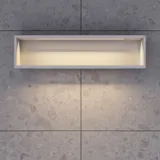 Lite, stilfullt baderom med mørkeblå vegger, myke gule baderomsmøbler med riller, og elegant rundt speil med lampe.