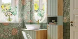 Baderomsinspirasjon med baderomsmøbler i grønn spesialfarge med sider i naturlig eik, elegante riller, stilfull benkeplate med romantisk oval bordstående servant, vakkert ovalt speil, gir sammen med blomstrete tapet et yndefullt, vintage retro uttrykk.