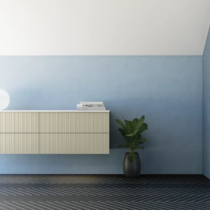 Baderom med skrått tak inspirasjon, beige baderomsmøbler med rifler, elegant benkeplate og firkantet bordstående servant, vakkert firkantet speil med stilige hyller, blå vegger, store vinduer og sort fiskebeinsgulv gir et lyst og urbant uttrykk.