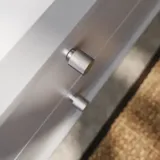 Baderomsinspirasjon med skråvegger, grå servantskap og overskap, spesialtilpassede benkeplater, moderne firkantet bordstående servant, firkantet speil med lys, rå betongvegger og gulv gir et urbant uttrykk