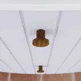 Stor baderomsinspirasjon med hvite møbler med riller, elegante benkeplater og bordstående servanter, ovale speil med lys, synlige bjelker og mønstrede fliser gir et vintage og stilfullt uttrykk