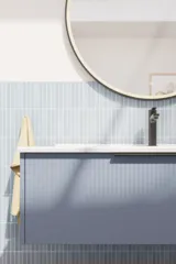 Baderomsinspirasjon med avlange lyseblå fliser og betongulv, elegant vaskeskap i lys blå med vakre smale striper, stilren og tynn vask samt minimalistisk rundt speil med svart kant og lys, som gir et snev av eleganse til baderommet ditt.