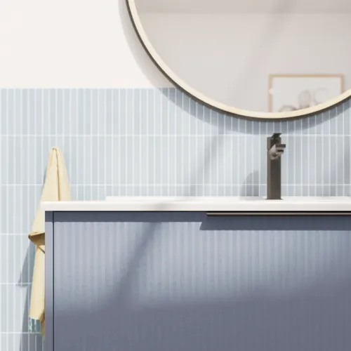 Baderomsinspirasjon med avlange lyseblå fliser og betongulv, elegant vaskeskap i lys blå med vakre smale striper, stilren og tynn vask samt minimalistisk rundt speil med svart kant og lys, som gir et snev av eleganse til baderommet ditt.