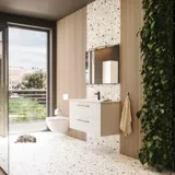 Stor baderomsinspirasjon med baderomsmøbler i matt hvitt med elegant servant og firkantet speil med svart kant og lampe, terrazzovegg og -gulv og planter på veggen for et moderne og sofistikert uttrykk.