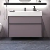 Baderom med skrå vegger inspirasjon, med baderomsmøbler i lilla med elegante rammefronter, flott oval speil med lampe, vakker og praktisk hylle, samt lilla malt vegg og grått fiskebeinsgulv som gir et elegant og moderne uttrykk.